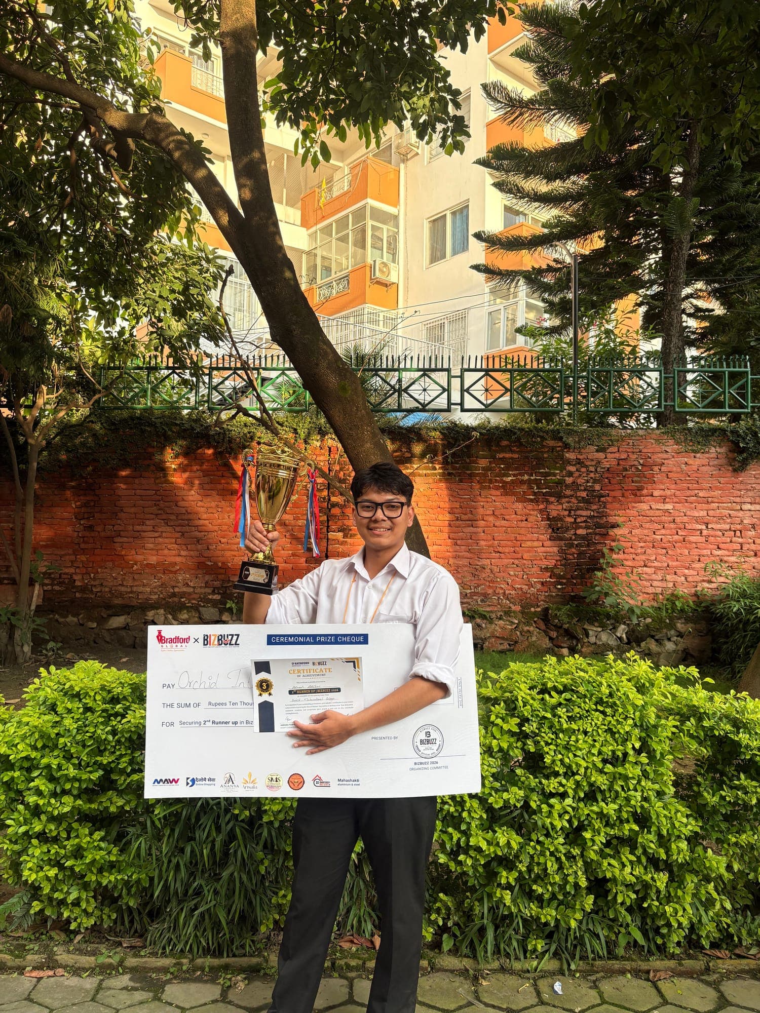 Abinash holding the BizBuzz trophy and the ceremonial prize cheque